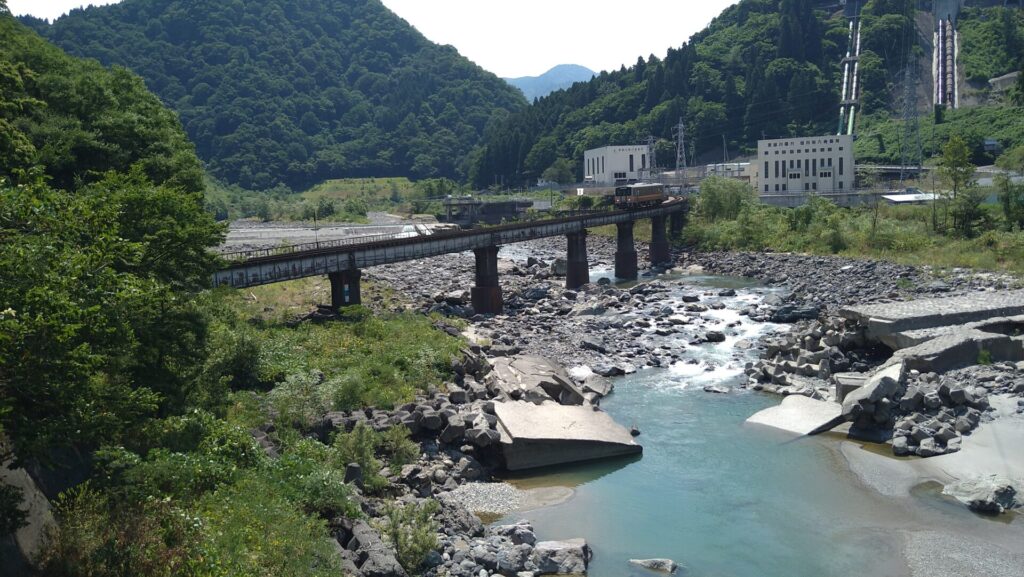 姫川第七発電所取水堰付近を通る列車